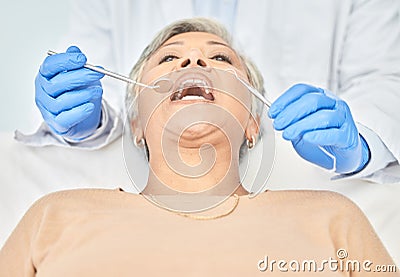 Tools, mature woman and hands of dentist in healthcare, check and dental wellness in clinic. Oral, orthodontics and Stock Photo