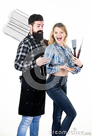 Tools for roasting meat outdoors. Picnic and barbecue. Bearded hipster and girl ready for barbecue party. Roasting and Stock Photo
