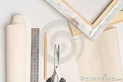 Tools for stretching canvas on a wooden frame top view. Canvas, pencil, scissors ruler and wooden stretcher with canvas roll Stock Photo