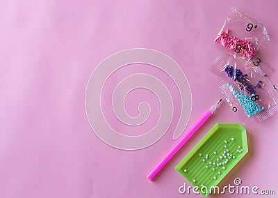 Tools - stylus for gluing diamond mosaic and green plastic tray, small beads in bags Stock Photo