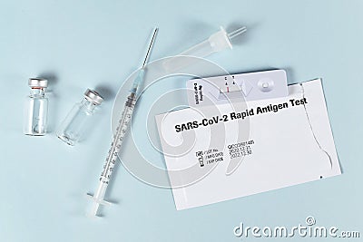 Tools to fight Corona Virus pandemic including rapid antigen test and vaccine vials with syringe Editorial Stock Photo