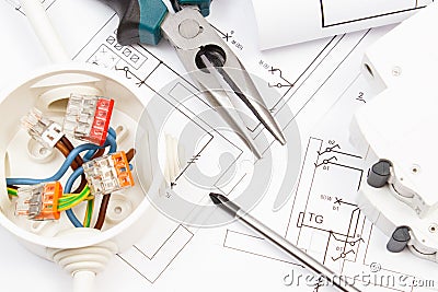 Tools using for works, electric fuse and box with connected colorful cables and diagrams of plan with electrical installation. Stock Photo