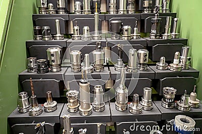 Tools for working on a CNC machine are arranged in racks for quick search and selection Stock Photo