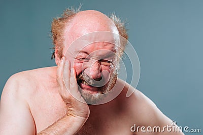 Toothache does not give rest an undressed old man hold cheek with hand tooth inflamed nerve hurts. Stock Photo