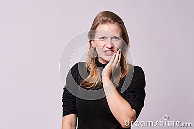 Toothache. Unpleasant sensations. Beautiful girl Stock Photo