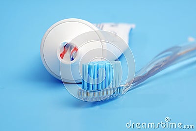 Toothbrush with toothpaste on it and white toothpaste tube on blue background Stock Photo