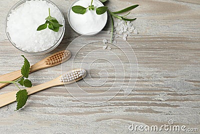 Toothbrushes, green herbs and sea salt on wooden table, flat lay. Space for text Stock Photo