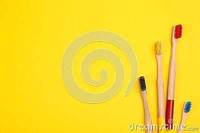 Toothbrushes made of bamboo on yellow, flat lay. Space for text Stock Photo