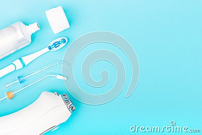 Toothpaste, toothbrush and dental irrigator on blue background with copy space Stock Photo