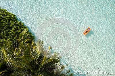 Top above high angle aerial drone view of fit slim attractive wealthy rich girl floating on rubber mattress clear clean Stock Photo