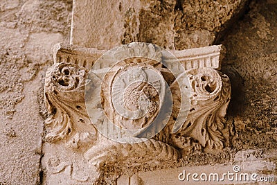 The top of a bas-relief column with a shield pattern depicting a dragon, in the old town of Kotor, Montenegro. Stock Photo