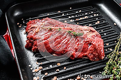 Top blade steak on a grill pan, raw meat, marbled beef . Black background. Top view Stock Photo