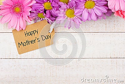 Top border of flowers with Mothers Day gift tag against white wood Stock Photo