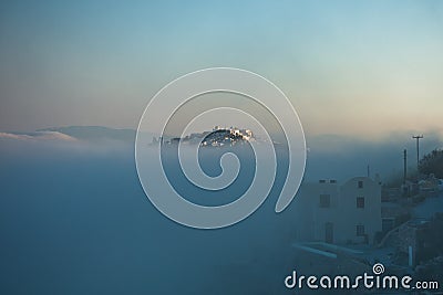 Top of Caldera cliff above the fog at sunny sunrise, village of Imerovigli, Santorini island Stock Photo