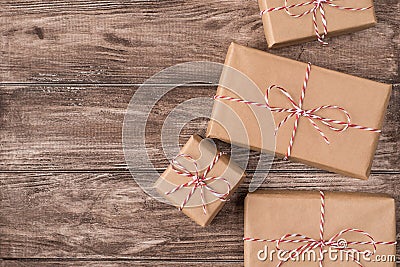 Top close up flatlay photo of pile of boxes packed in craft paper with red and white striped rope lying on wooden desk Stock Photo