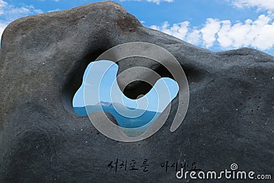 Top crater of hallasan mountain volcano seen through a stone sculpture in a park in Seogwipo, Jeju Island, Korea Stock Photo