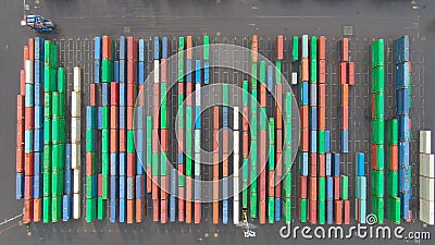 TOP DOWN: Industrial forklift drives past rows of multicolored containers. Editorial Stock Photo