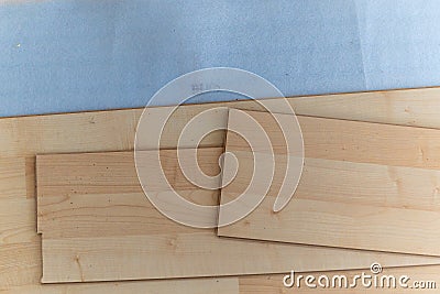 A top down portrait of stacked wood imitation laminate floorboards lying on some sound isolation ready to be installed to create a Stock Photo