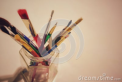 Top down view of artist brushes in a clar jar on a light background. Stock Photo