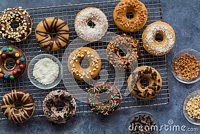 Assorted homemade donuts with various glazes and toppings, on a cooling rack. Stock Photo