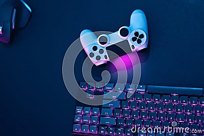 Top down view of controlling devices. Purple backlit computer keyboard, mouse and game controller Stock Photo
