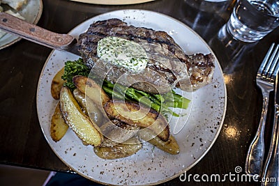 Top down view of a delectable steak frites dinner on a wooden table inside a restaurant Stock Photo