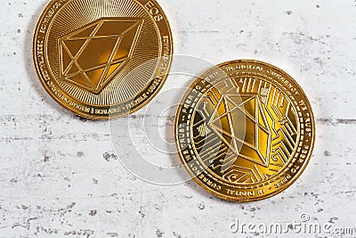 Top down view, detail of golden commemorative EOS - EOSIO cryptocurrency - coins on white stone board Editorial Stock Photo