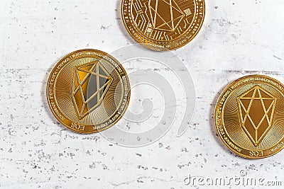 Top down view, golden commemorative EOS - EOSIO cryptocurrency - coins on white stone board Stock Photo