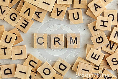 Top down view, pile of square wooden blocks with letters CRM stands for Customer Relationship Management on white board Stock Photo