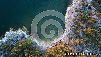 Top-down view rocky beach and clear blue water background. Stock Photo