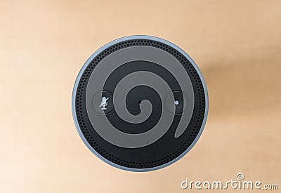 Top-down view of a well-known Smart Speaker and Assistant showing its minimal controls. Editorial Stock Photo