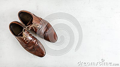 Top down view, worn classic dark brown brogue shoes on white board. Wide banner with space for text right Stock Photo