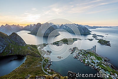 From top of the famous Reinebringen overlooking the city of Reine in Lofoten,Norway during the midnight sun. Stock Photo