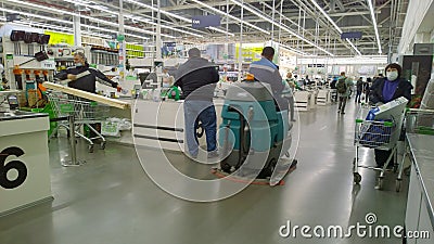 Top largest supermarket. Retail industry. Cleaning floor. Service staff. Customers in protective medical masks. Shopping mall. Vir Editorial Stock Photo