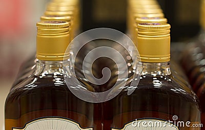 Top of plastic bottles with cognac or brandy standing in the liquor store. From the front. Stock Photo