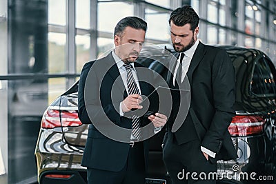 Top sales manager and customer at dealership showroom Stock Photo