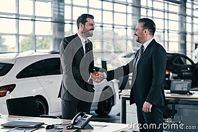 Top sales manager and customer at dealership showroom Stock Photo