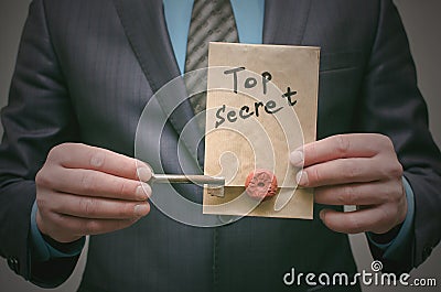 Top secret concept. Top secret documents or message and a decryption key in businessman hands. Stock Photo
