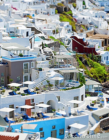 Top view from above of Santorini villas. Panorama of small houses with blue water swimming pool on white terrace, blur background Stock Photo