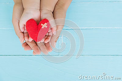 Top view of adult and child holding red heart in hands Stock Photo
