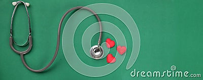 Image of a top view stethoscope and red heart on a green background, concept of health and medicine. Stock Photo