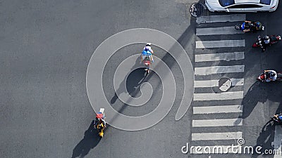 Top view aerial photo of motorcycle driving pass pedestrian crosswalk in traffic road with light and shadow silhouette Editorial Stock Photo