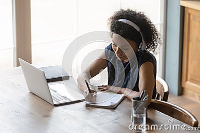Top view African American woman in headphones taking notes Stock Photo
