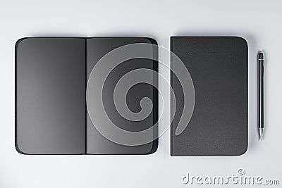 Top view on all-black notebooks with black empty pages and plain pen on white surface background. 3D rendering Stock Photo