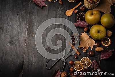 Top view of apples, nuts, oranges, cinnamon, scissors and autumn leaves, on a dark wooden background, Stock Photo