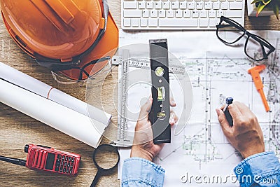 Top View Architect working on blueprint. Architects workplace. Engineer tools and safety control, blueprints, ruler, orange helm Stock Photo