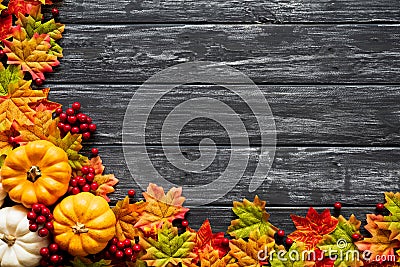 Top view of Autumn maple leaves with Pumpkin and red berries on old wooden backgound. Stock Photo