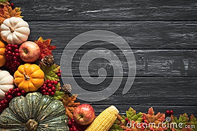 Top view of Autumn maple leaves with Pumpkin and red berries on old wooden backgound. Stock Photo