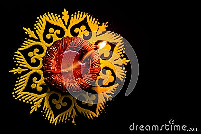 Top view of awesome glowing diya and rangoli on black backgorund with copy sapce. festival of light Stock Photo