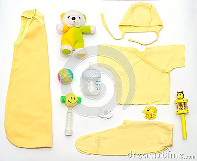 Top view of baby girl yellow clothes and toy stuff Stock Photo